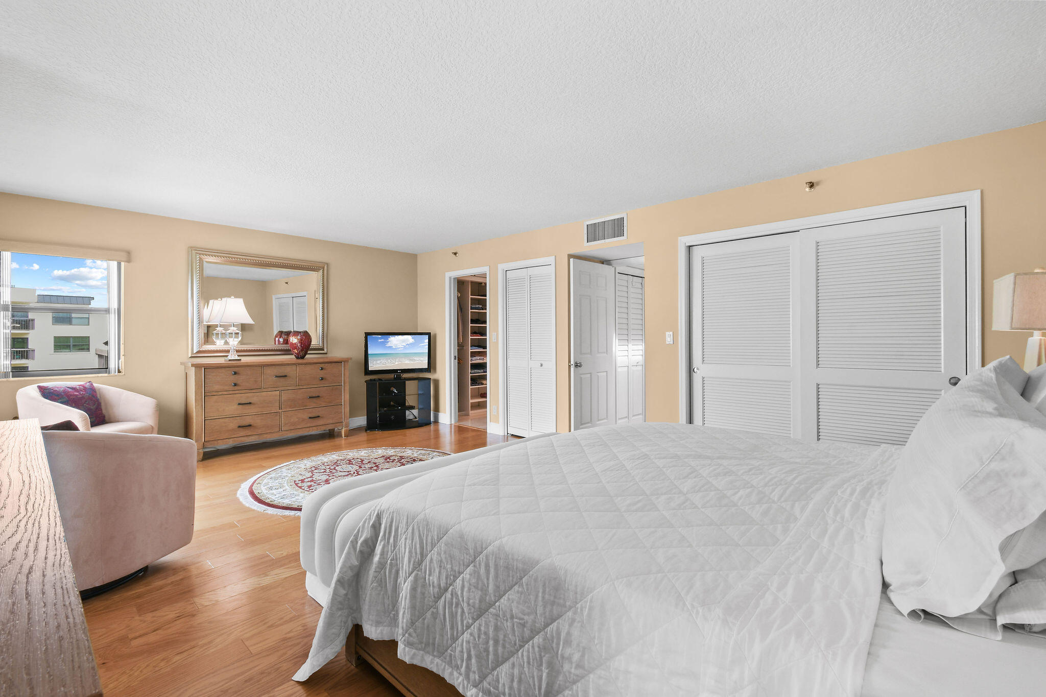 364 Golfview Road, Unit 506 North Palm Beach, FL 33408 - Photo 24 of 44 a spacious bedroom with a bed and wooden floor