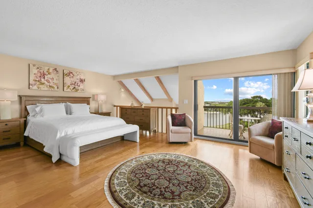 a spacious bedroom with a bed a couch and a large window with outer view