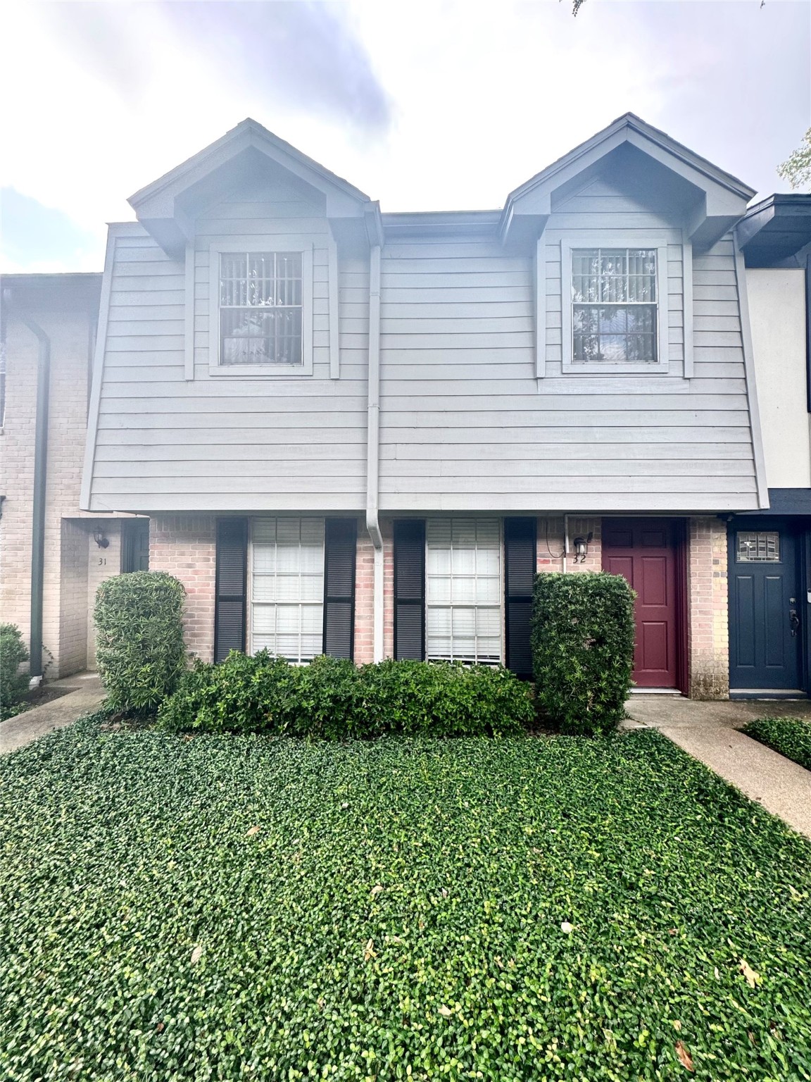 10010 Knoboak Drive, Unit 32 Houston, TX 77080 - Photo 2 of 17 a front view of a house with a yard and garage