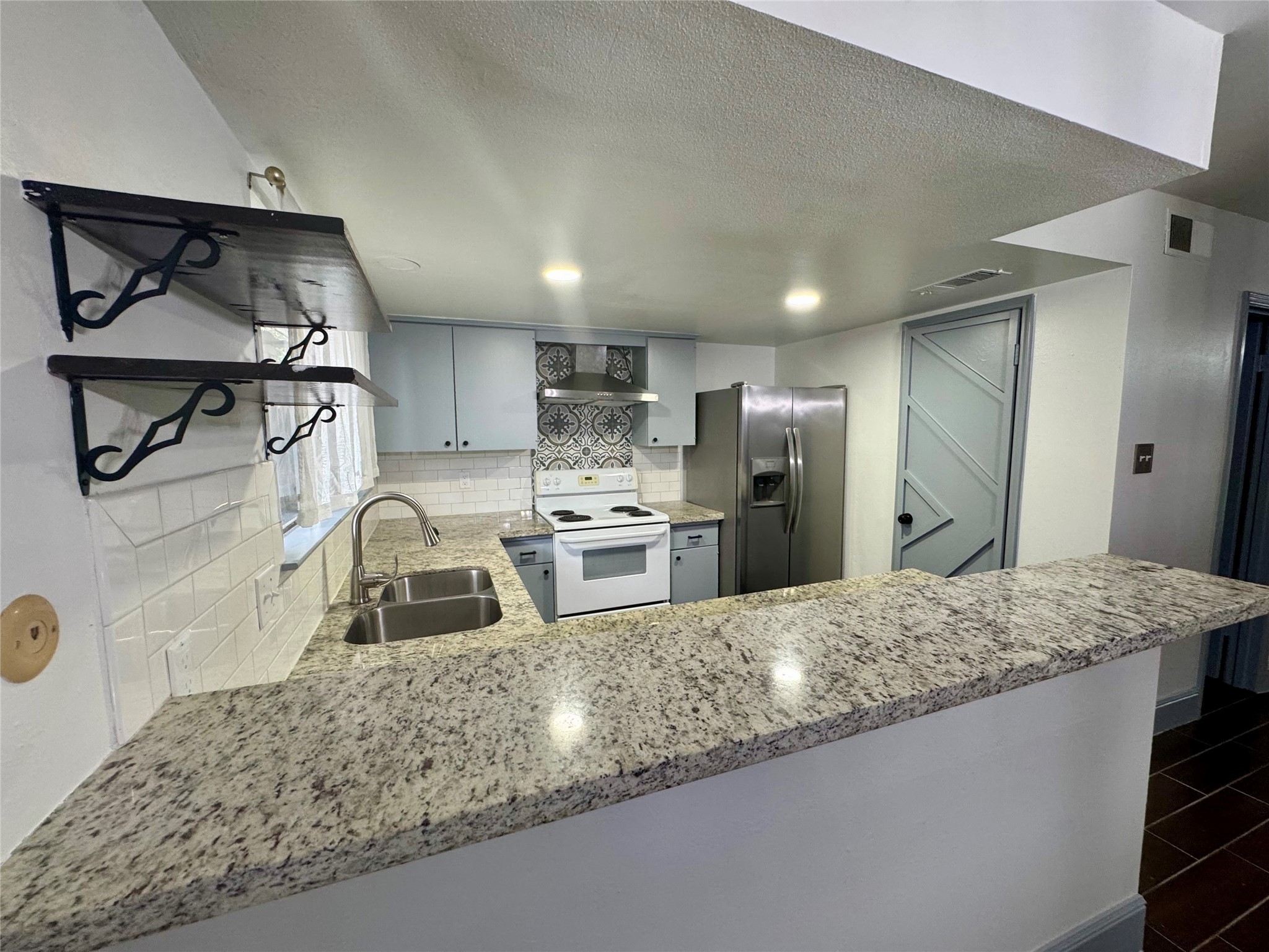 10010 Knoboak Drive, Unit 32 Houston, TX 77080 - Photo 5 of 17 a kitchen with stainless steel appliances granite countertop a sink refrigerator and cabinets