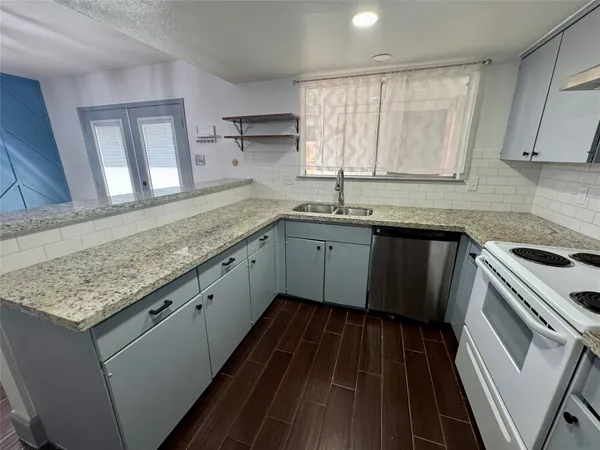 a kitchen with a sink stove and cabinets