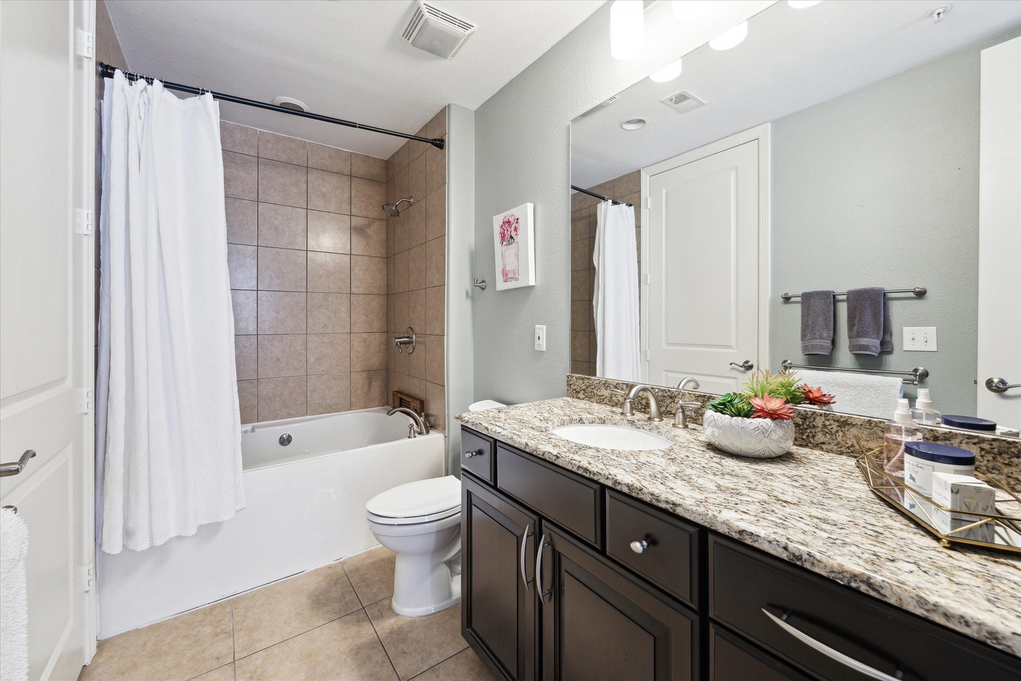 2120 Kipling Street, Unit 304 Houston, TX 77098 - Photo 15 of 21 a bathroom with a granite countertop sink mirror toilet and bathtub