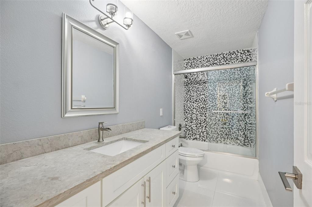 1978 Applegate Drive Ocoee, FL 34761 - Photo 32 of 50 a bathroom with a granite countertop sink a toilet a mirror and shower