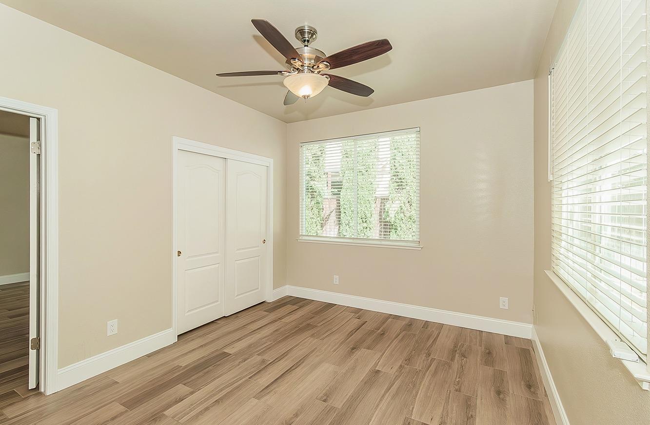 735 West Brittany Lane Clovis, CA 93619 - Photo 11 of 30 a view of an empty room with wooden floor and a window