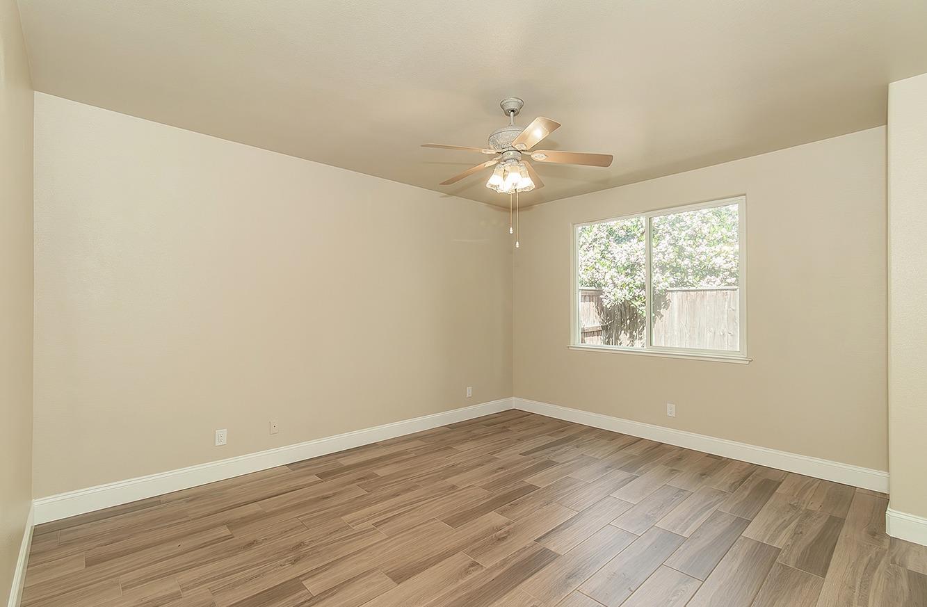 735 West Brittany Lane Clovis, CA 93619 - Photo 13 of 30 an empty room with wooden floor and windows