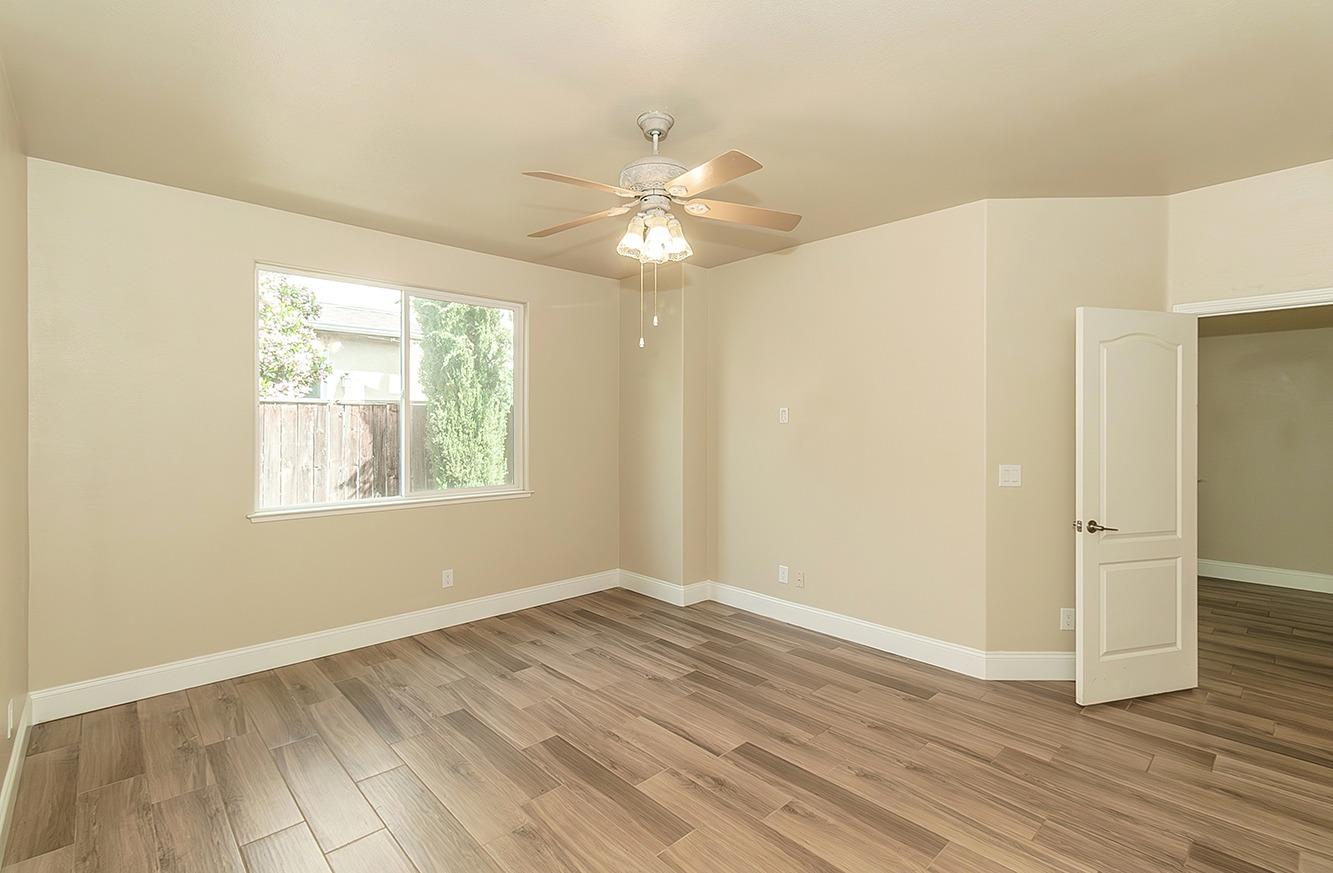 735 West Brittany Lane Clovis, CA 93619 - Photo 14 of 30 a view of an empty room with wooden floor and a window