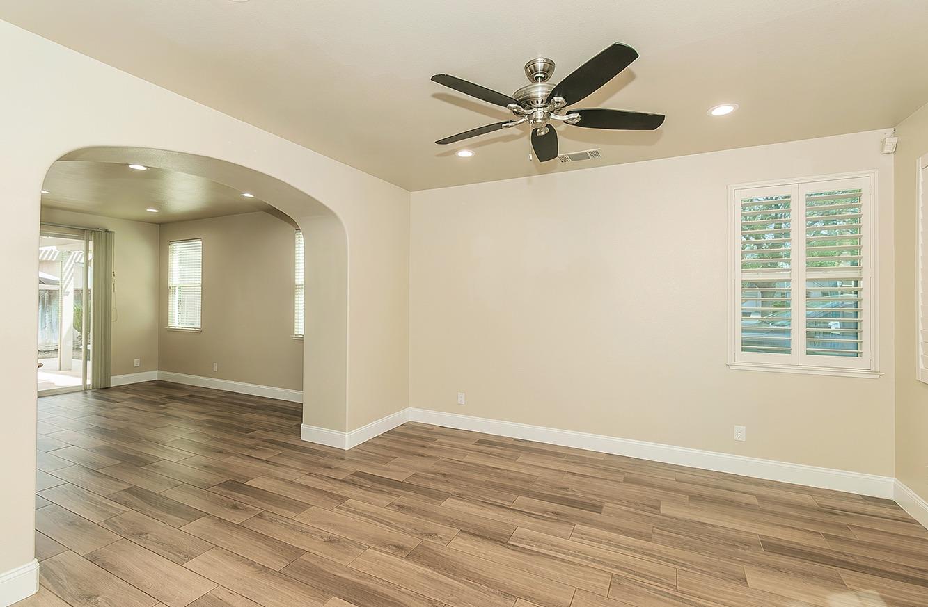 735 West Brittany Lane Clovis, CA 93619 - Photo 4 of 30 an empty room with wooden floor fan and windows