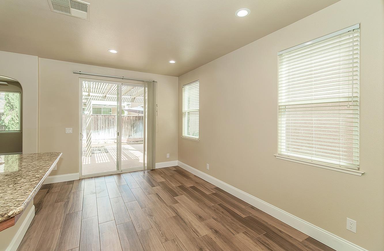 735 West Brittany Lane Clovis, CA 93619 - Photo 5 of 30 a view of an empty room with wooden floor and a window