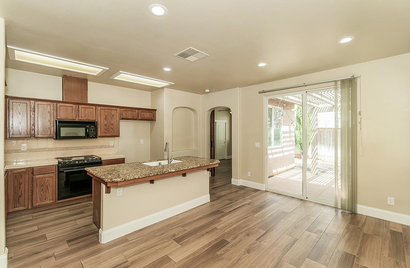 735 West Brittany Lane Clovis, CA 93619 - Photo 6 of 30 a large kitchen with stainless steel appliances granite countertop a stove and a sink
