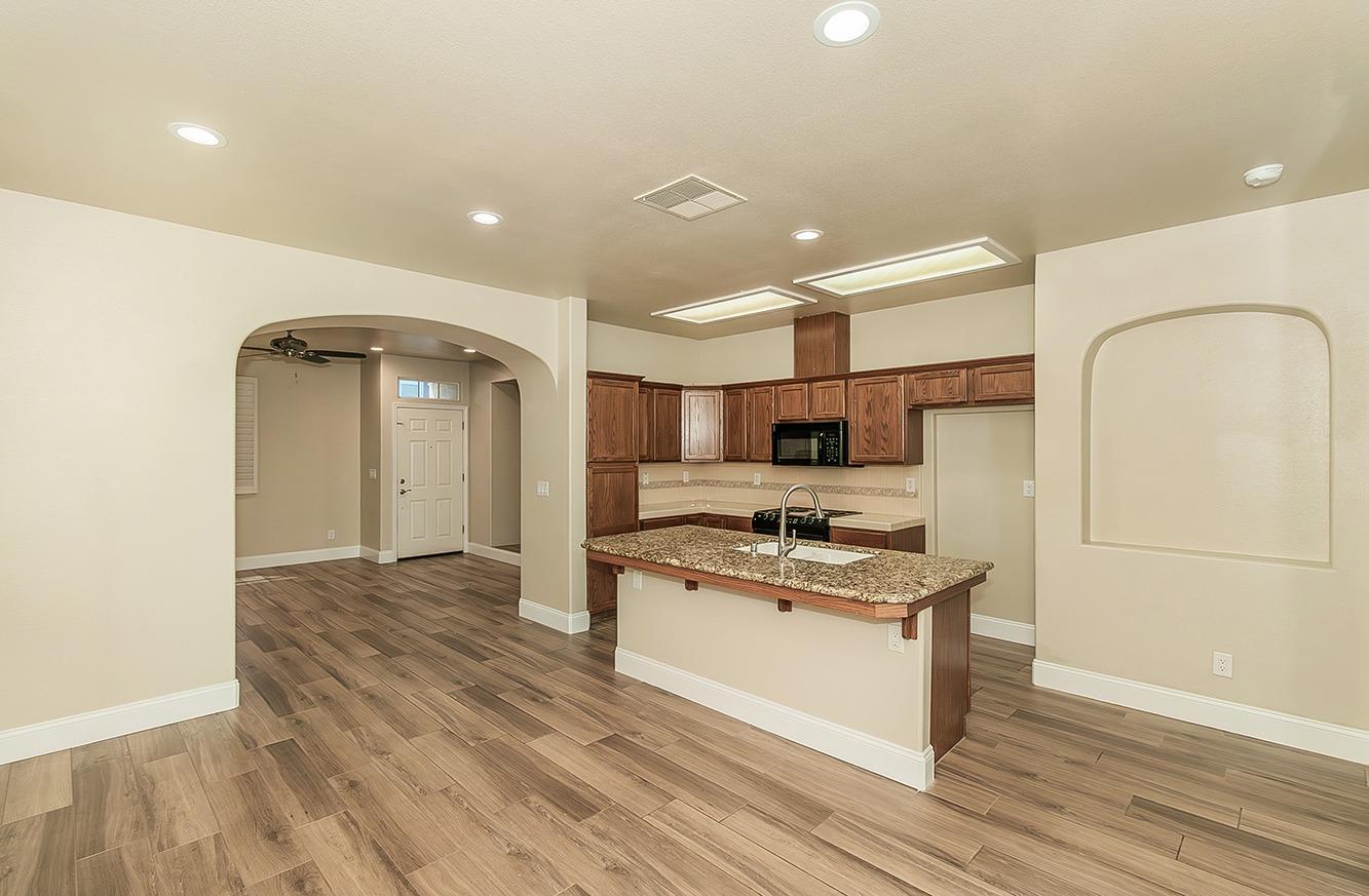 735 West Brittany Lane Clovis, CA 93619 - Photo 7 of 30 a kitchen with stainless steel appliances granite countertop a stove a sink and a refrigerator
