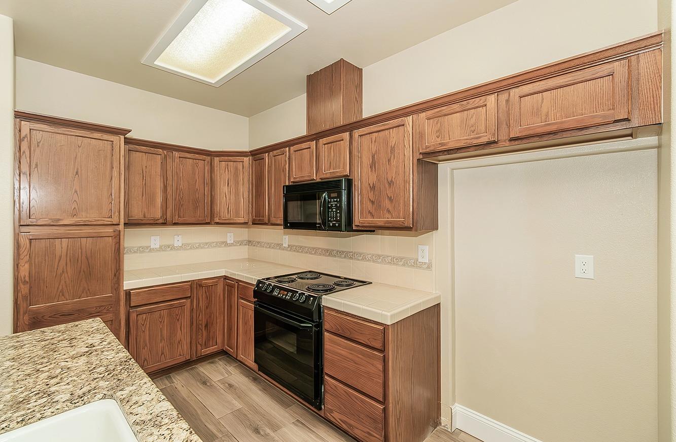 735 West Brittany Lane Clovis, CA 93619 - Photo 8 of 30 a kitchen with stainless steel appliances granite countertop a refrigerator and a stove top oven