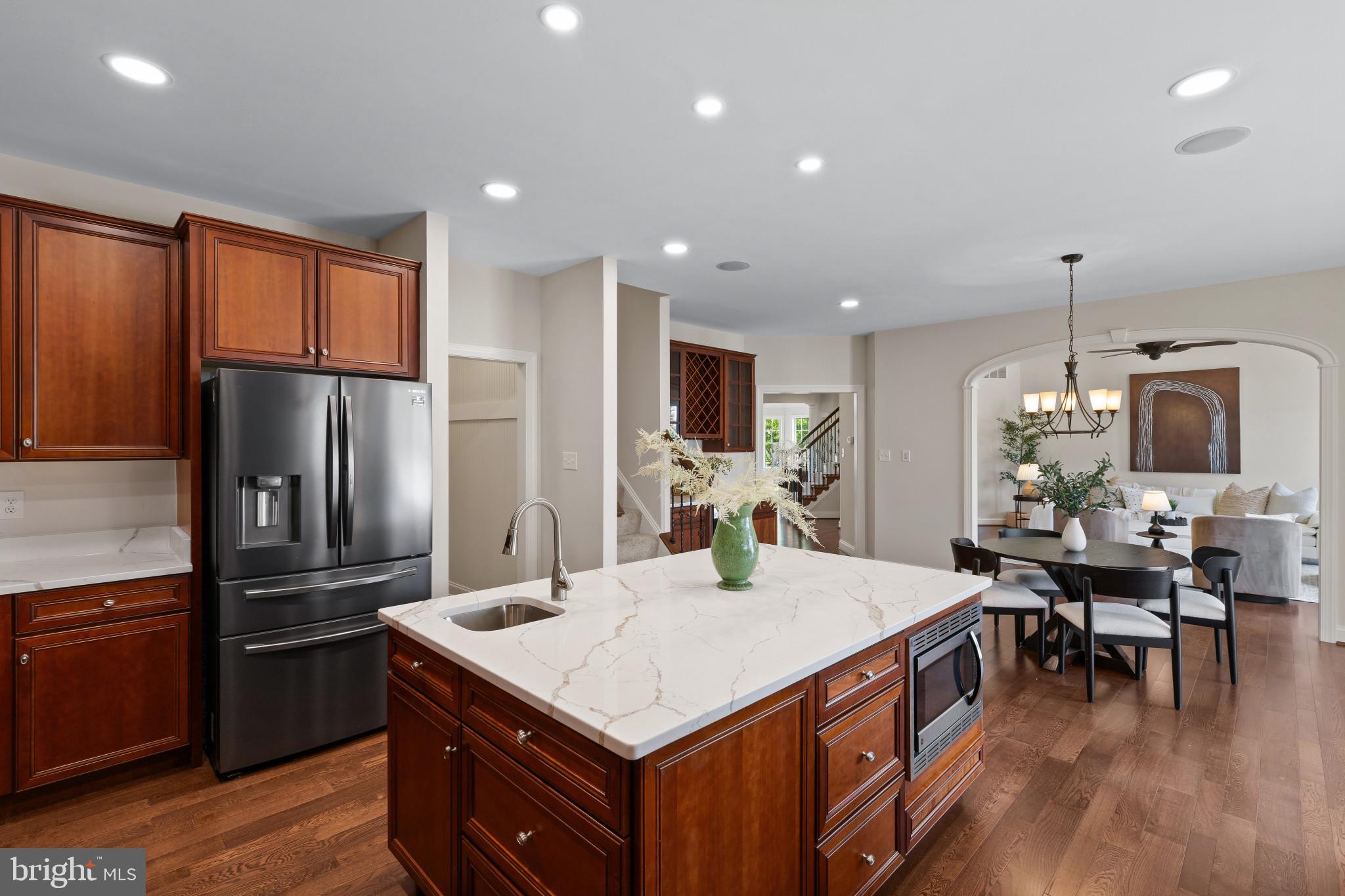 10725 Taylor Farm Road Woodstock, MD 21163 - Photo 16 of 70 a kitchen with stainless steel appliances granite countertop a refrigerator a stove a sink a dining table and chairs