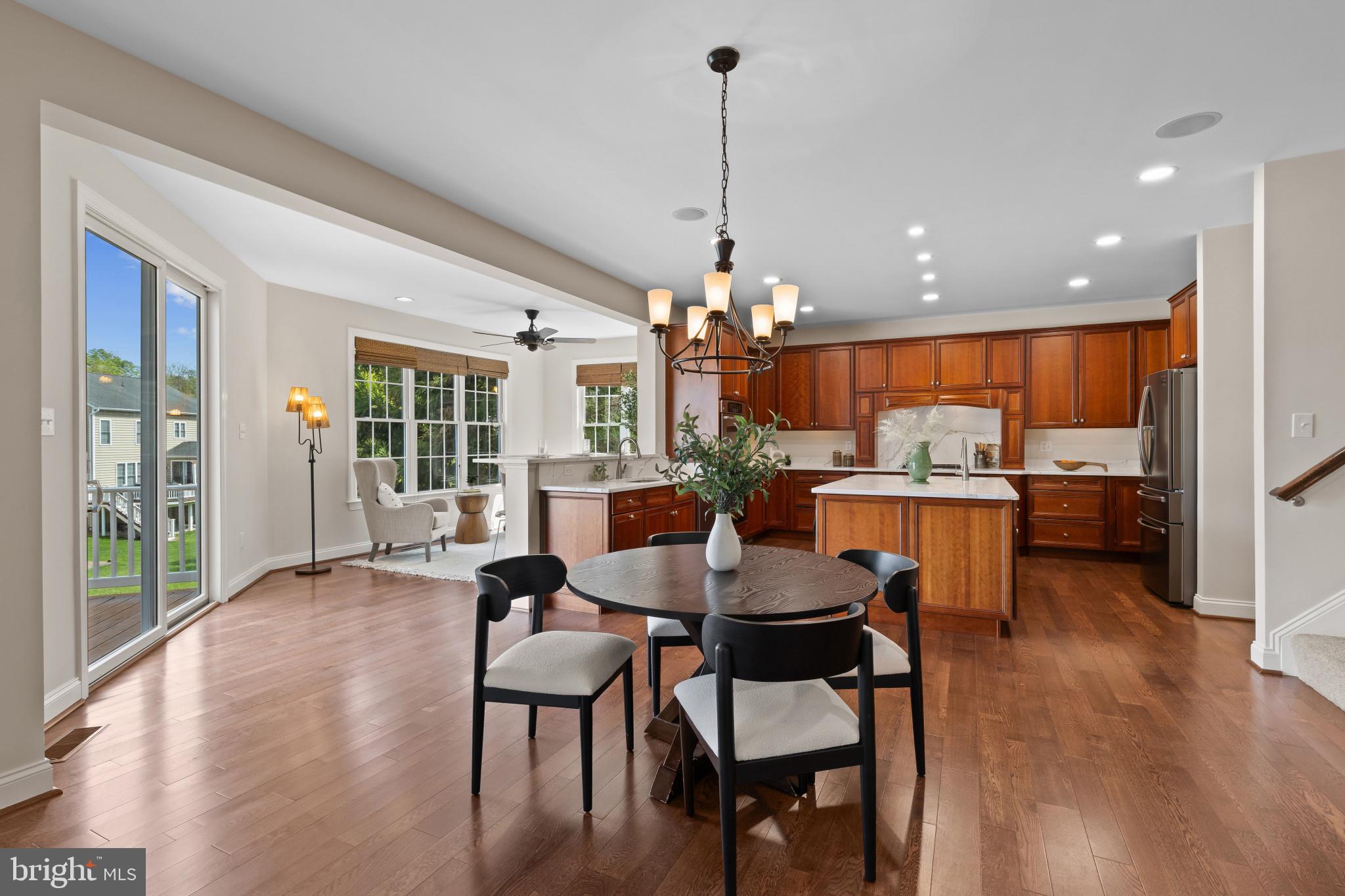 10725 Taylor Farm Road Woodstock, MD 21163 - Photo 18 of 70 a view of a dining room and livingroom with furniture wooden floor a chandelier