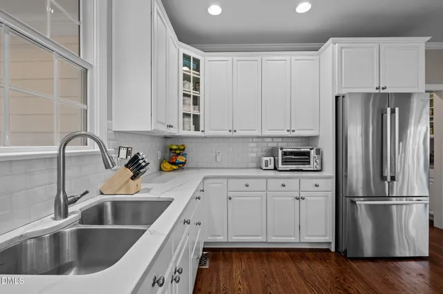 a kitchen with stainless steel appliances granite countertop a refrigerator sink and cabinets