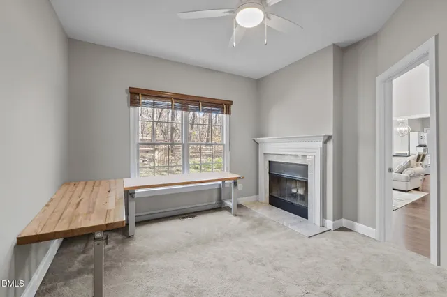 a view of a workspace with furniture and a window