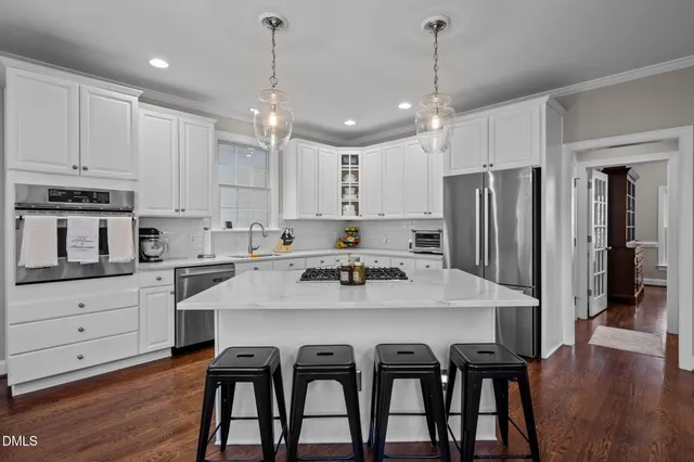 a kitchen with refrigerator a center island and chairs