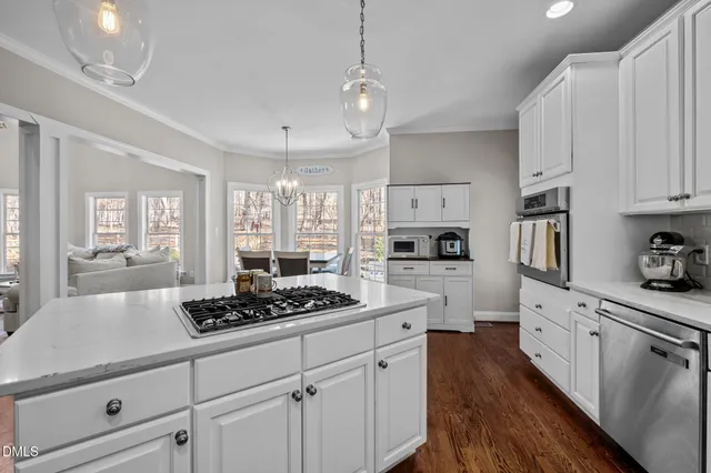 a kitchen with stainless steel appliances a stove a sink cabinets and a refrigerator
