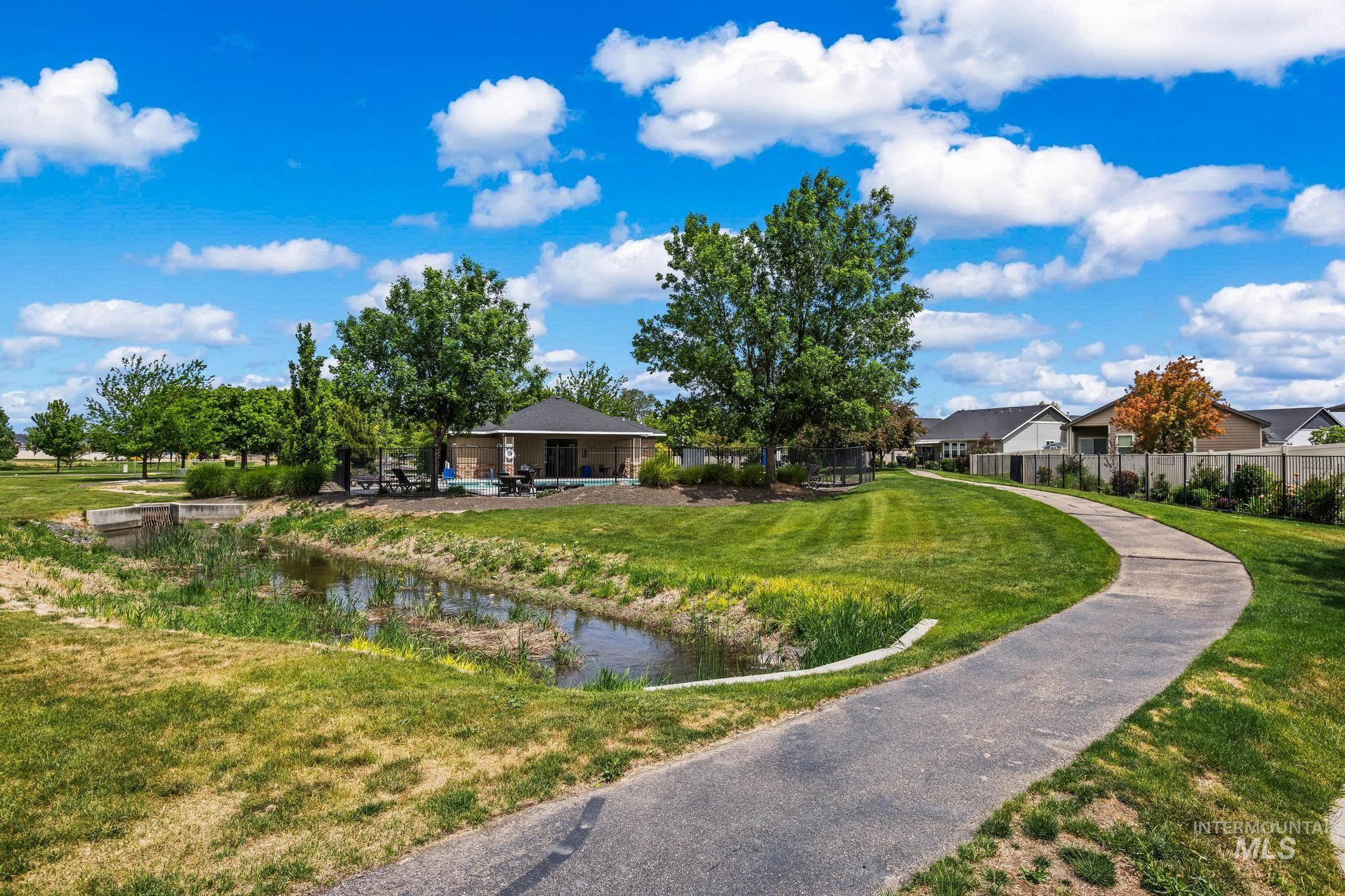 2681 East Rhyolite Court Nampa, ID 83686 - Photo 46 of 48 Curved concrete pathway bordering a grassy area with mature trees