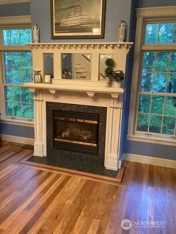 a living room with a fireplace and wooden floor