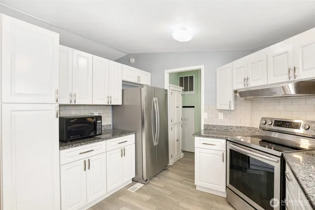 a kitchen with stainless steel appliances white cabinets and a sink