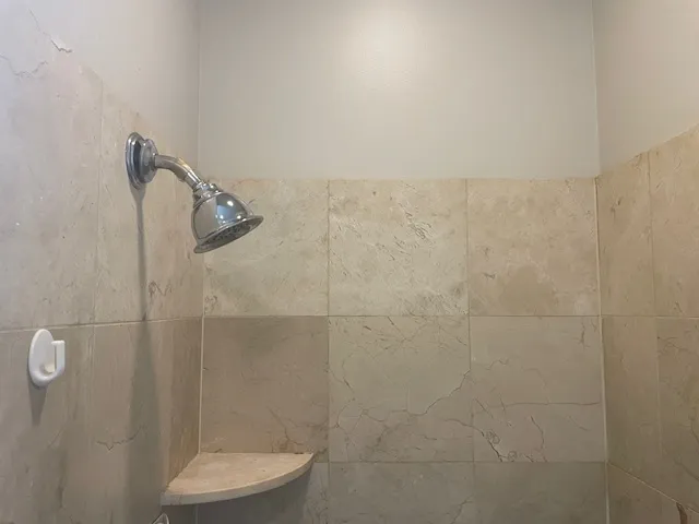 a bathroom with a granite countertop bathtub and shower