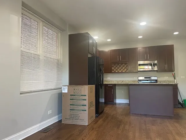 a kitchen with stainless steel appliances granite countertop a sink and a stove