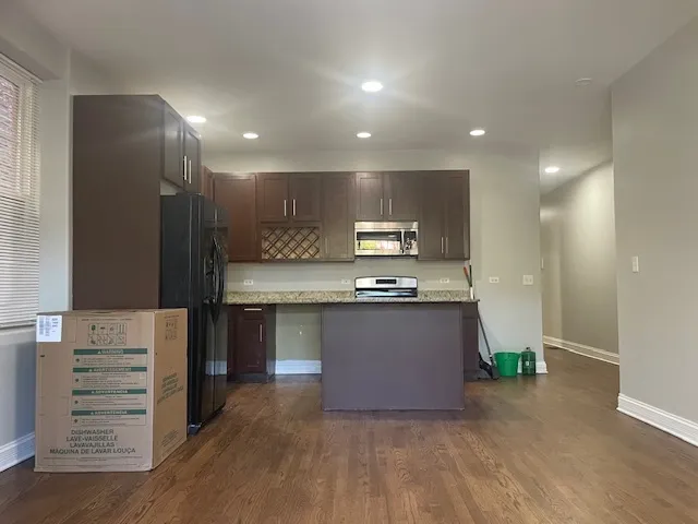 a large kitchen with a refrigerator and a stove top oven