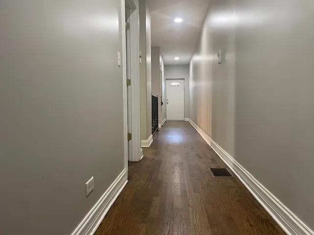 a view of a hallway with wooden floor