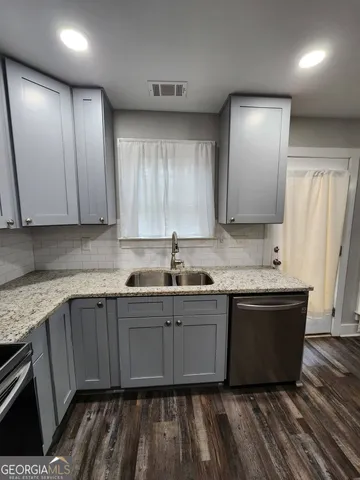 a kitchen with stainless steel appliances granite countertop a sink and a stove top oven