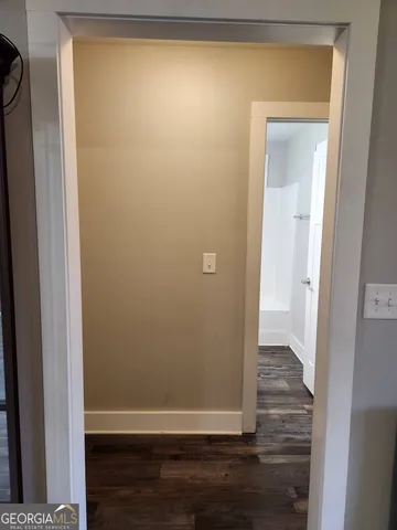 a view of a small space with wooden floor and a door