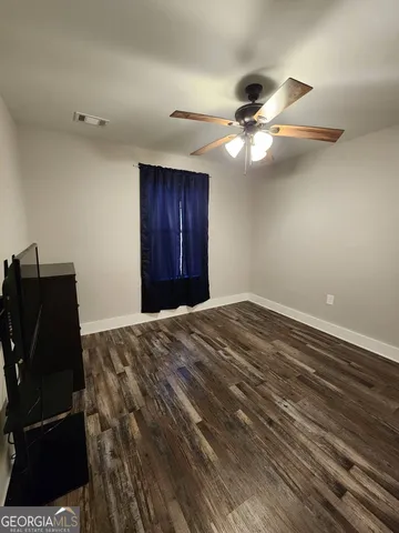 a bedroom with a bed and a ceiling fan