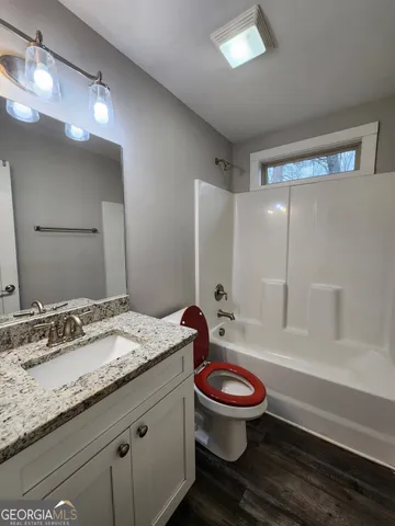 a bathroom with a granite countertop toilet a sink and a bathtub