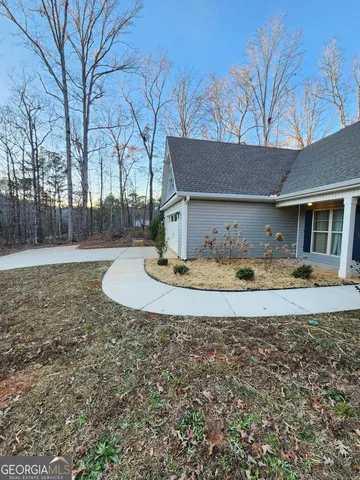a view of a house with backyard and trees