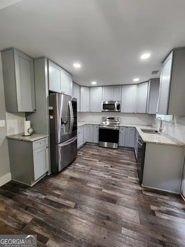 a kitchen with stainless steel appliances granite countertop a refrigerator sink and cabinets