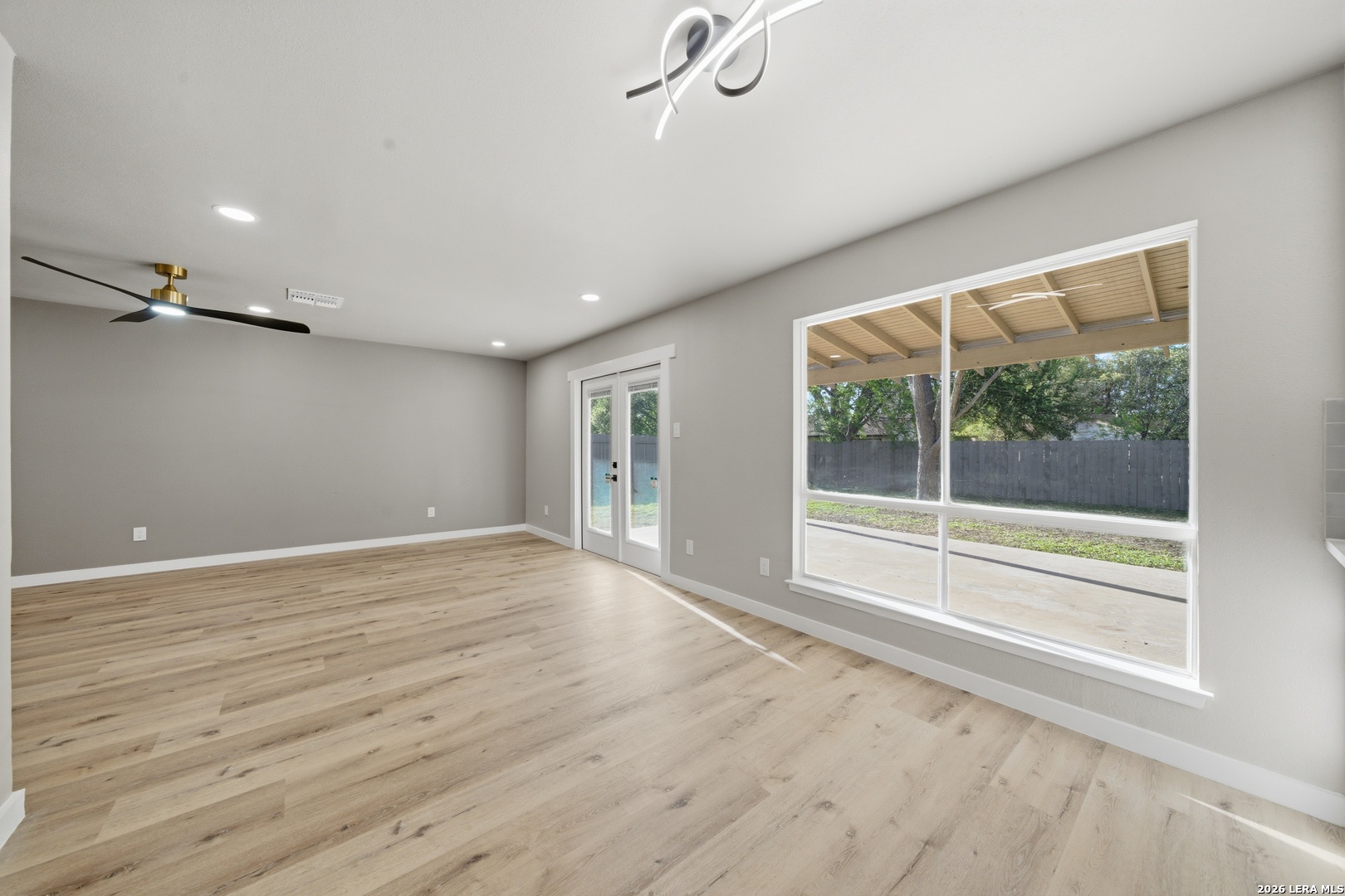 9446 Cliff Way Street San Antonio, TX 78250 - Photo 12 of 24 a view of an empty room with a window and wooden floor