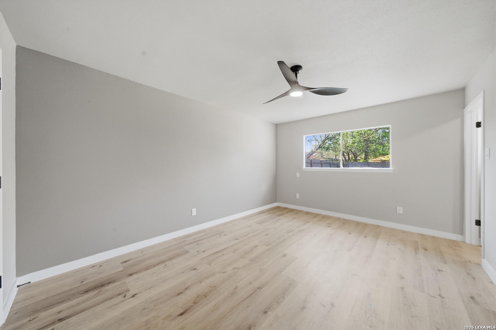 9446 Cliff Way Street San Antonio, TX 78250 - Photo 15 of 24 an empty room with wooden floor chandelier fan and windows