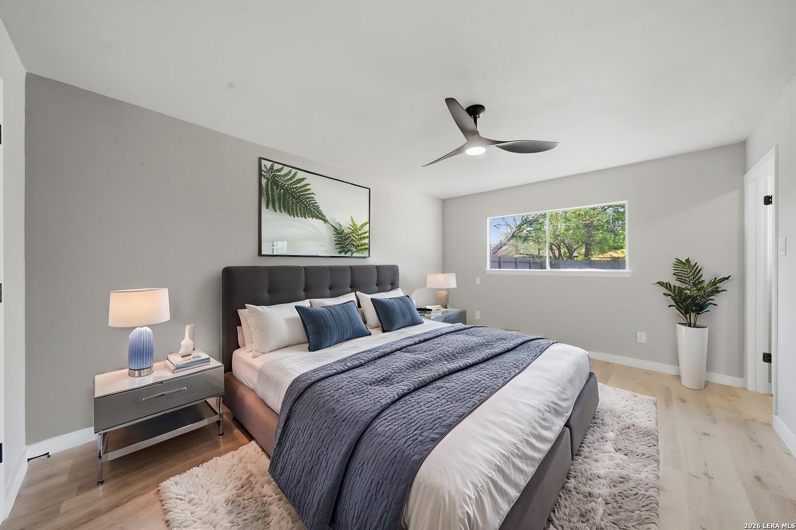 9446 Cliff Way Street San Antonio, TX 78250 - Photo 16 of 24 a bedroom with bed lamp and a potted plant