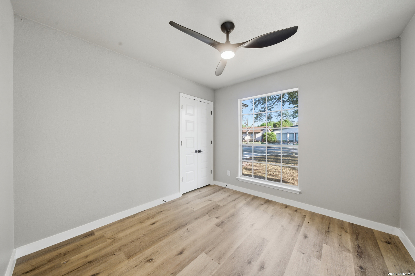 9446 Cliff Way Street San Antonio, TX 78250 - Photo 18 of 24 an empty room with wooden floor and windows