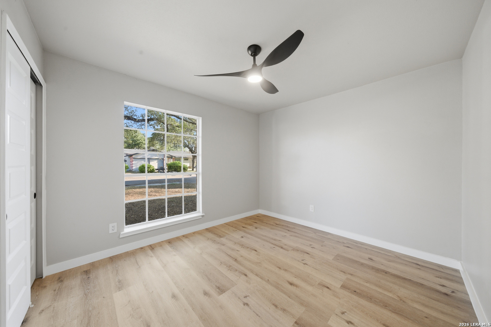 9446 Cliff Way Street San Antonio, TX 78250 - Photo 21 of 24 an empty room with wooden floor and windows