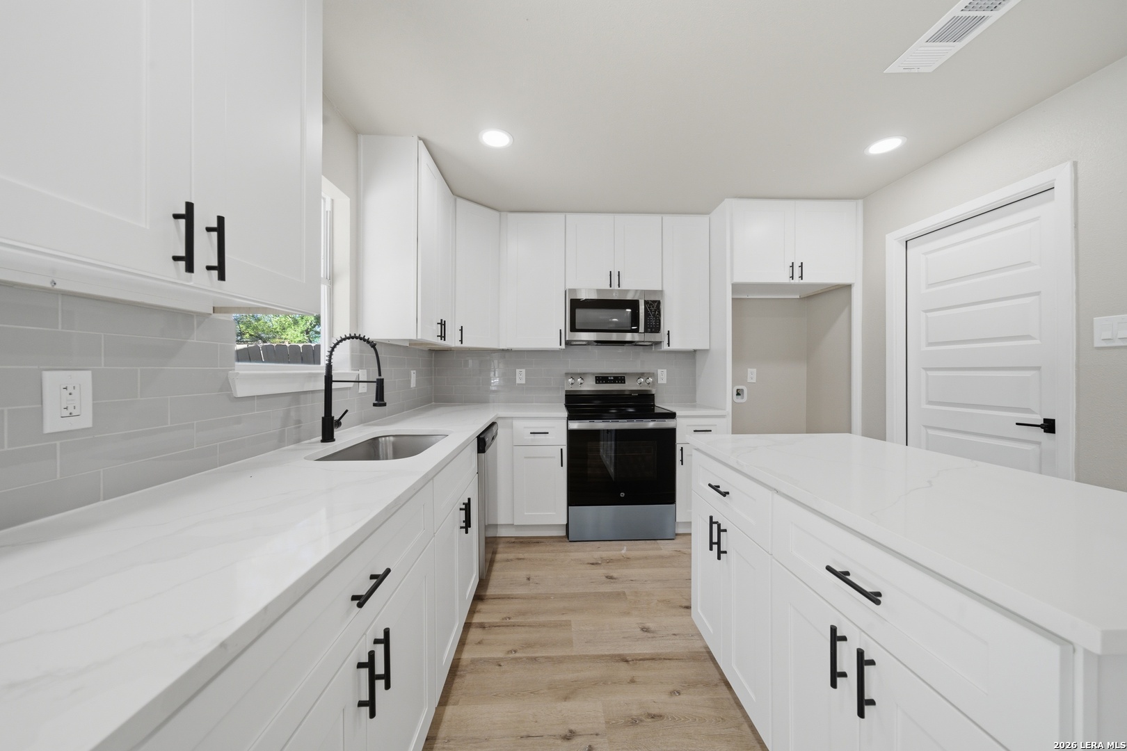 9446 Cliff Way Street San Antonio, TX 78250 - Photo 9 of 24 a kitchen with white cabinets sink and stainless steel appliances