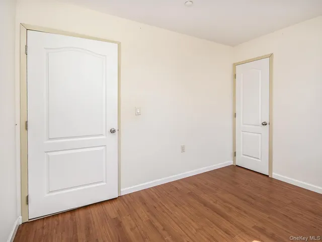 an empty room with wooden floor and closet
