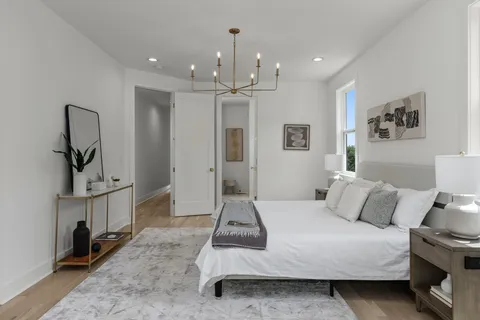 a bedroom with a bed and a chandelier