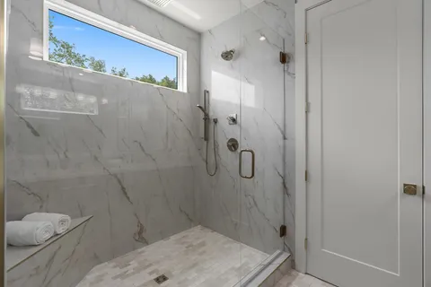 a bathroom with a granite countertop shower and toilet