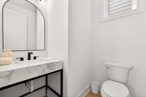 a bathroom with a granite countertop toilet sink and mirror