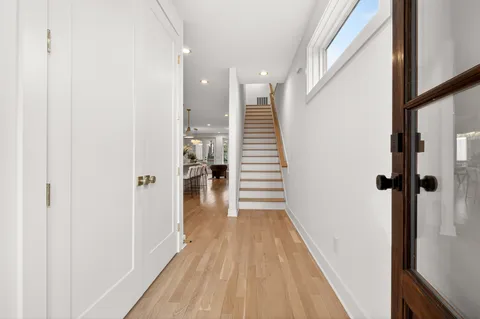 a view of a hallway with wooden floor and staircase