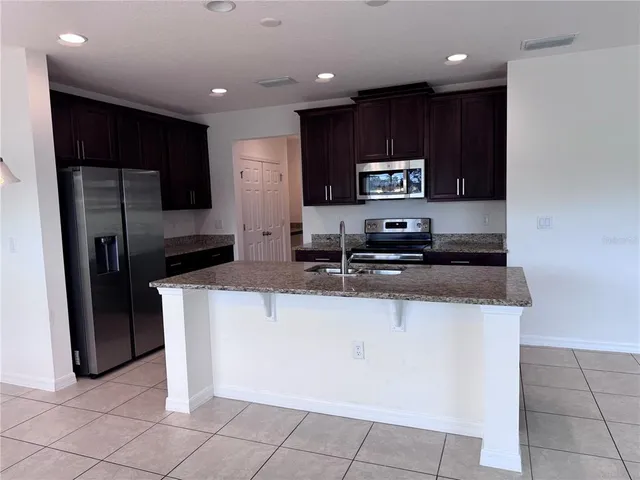a kitchen with stainless steel appliances granite countertop a refrigerator and a stove