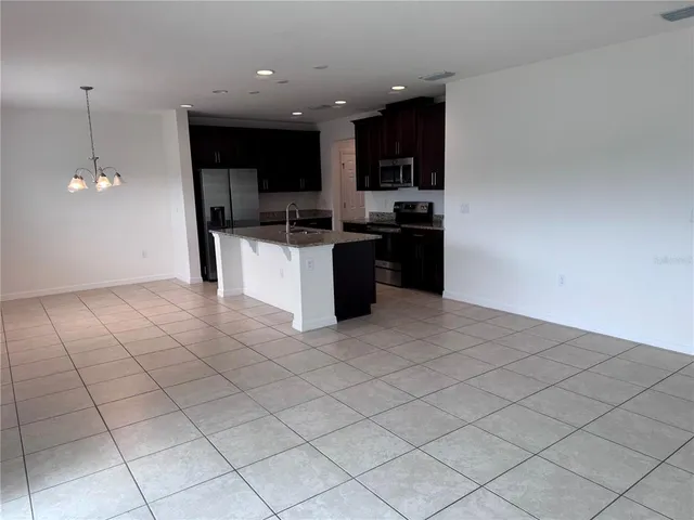 a open kitchen with stainless steel appliances granite countertop a refrigerator a sink and a stove