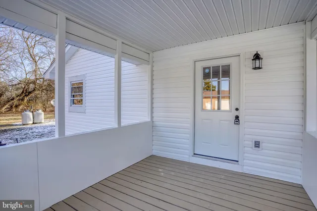 a view of a room with wooden floor and fan