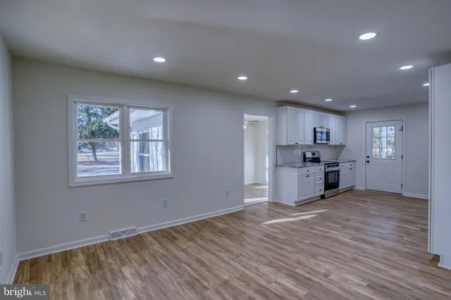 a kitchen with granite countertop white cabinets and stainless steel appliances