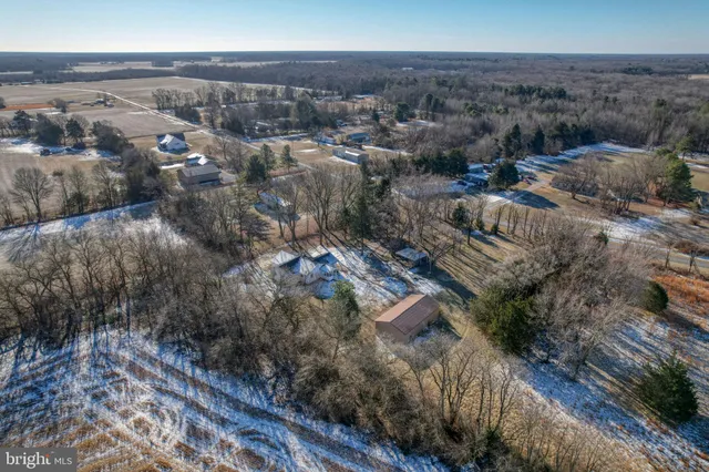 a view of a dry yard with wooden fence